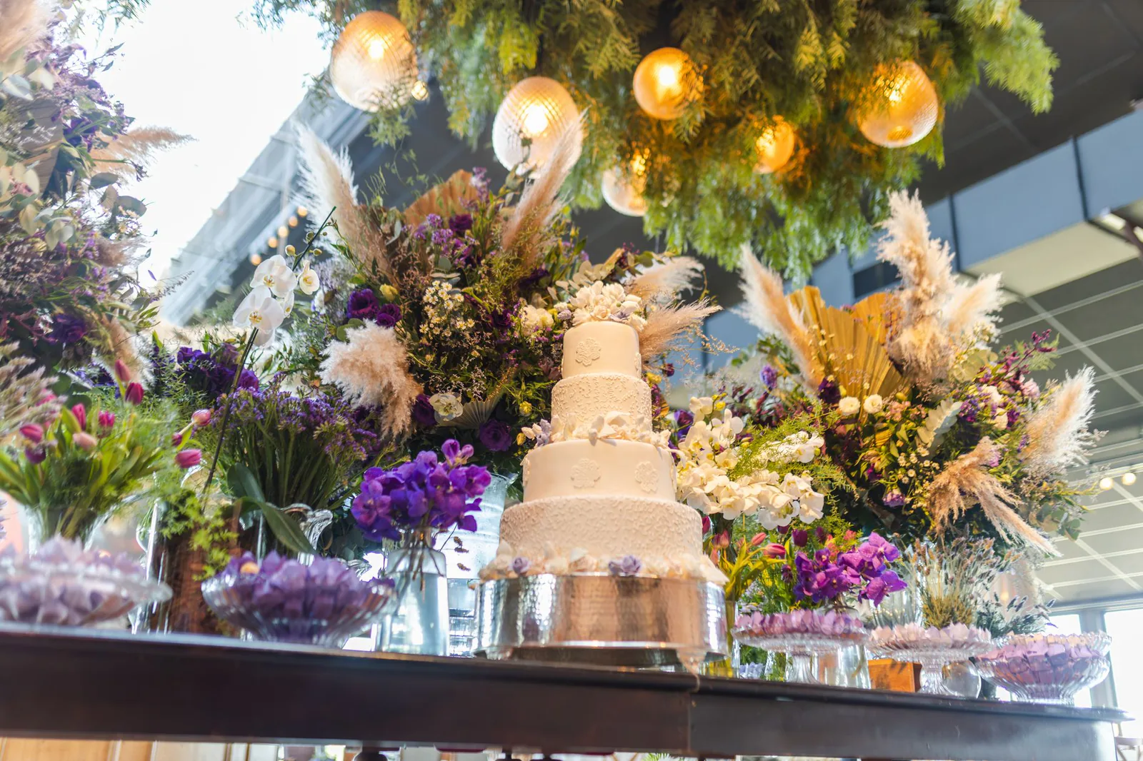 Stunning wedding reception setup with tiered cake and floral arrangements